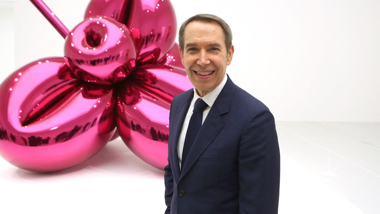 Der Künstler Jeff Koons steht vor einer seiner Skulpturen