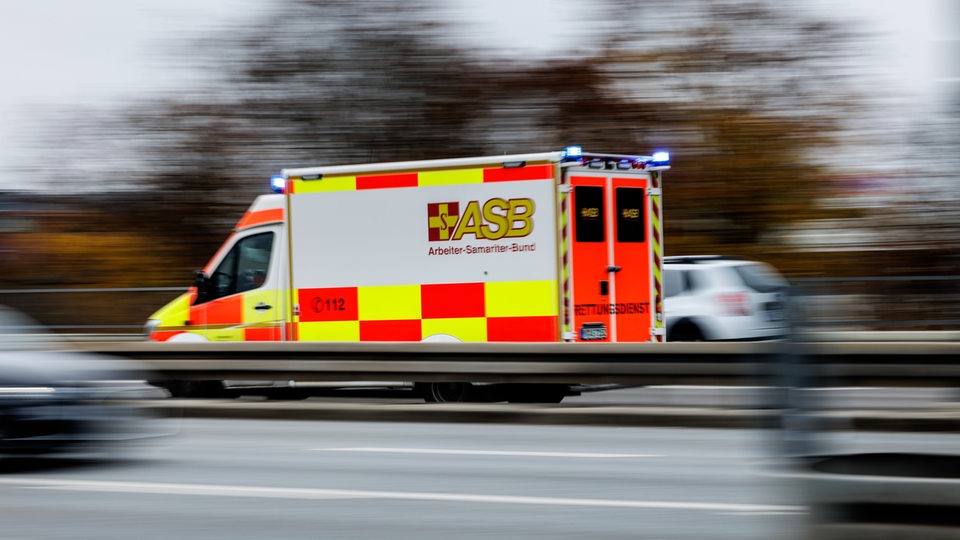 Ein Rettungswagen fährt zwischen anderen Autos auf der Autobahn.