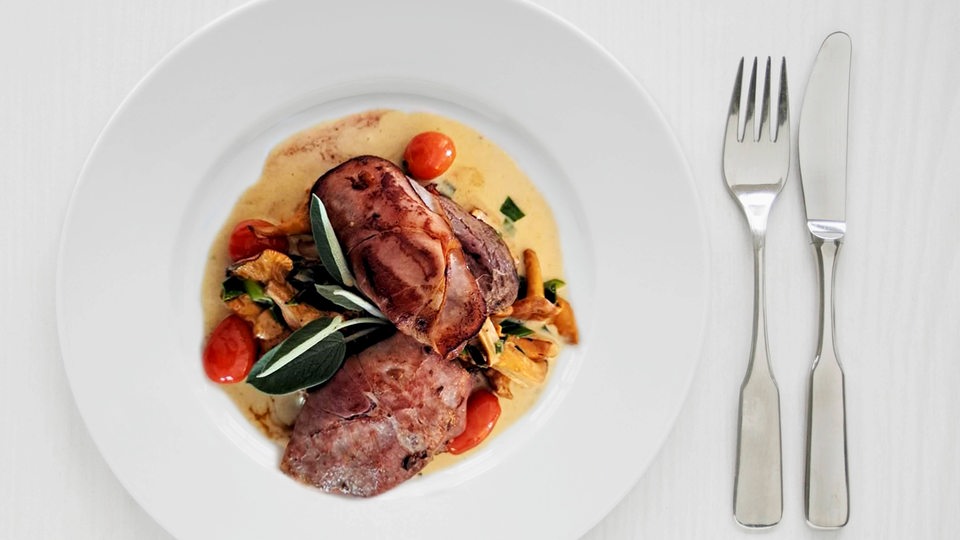 Auf dem Teller: Saltimbocca vom Dammwild mit Pfifferlingen, Kirschtomaten und Frühlingslauch a la creme dazu Servittenknödel