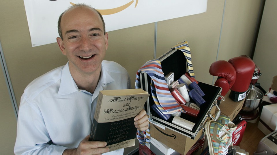 Jeff Bezos, Gründer von Amazon, sitzt 1996 in einem Zimmer voller mit Textilien und Kartons.