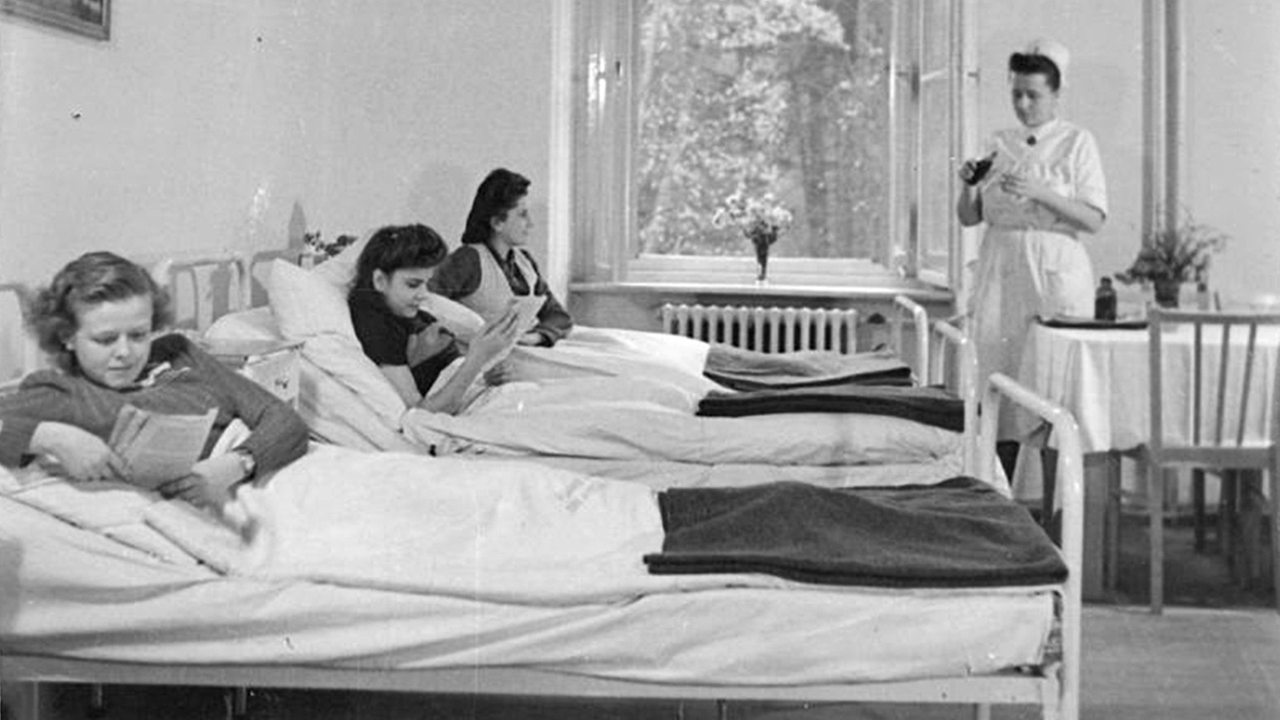 Ein Krankenzimmer in einem Tuberkulose Krankenhaus 1951. Mädchen liegen bei geöffnetem Fenster im Bett.