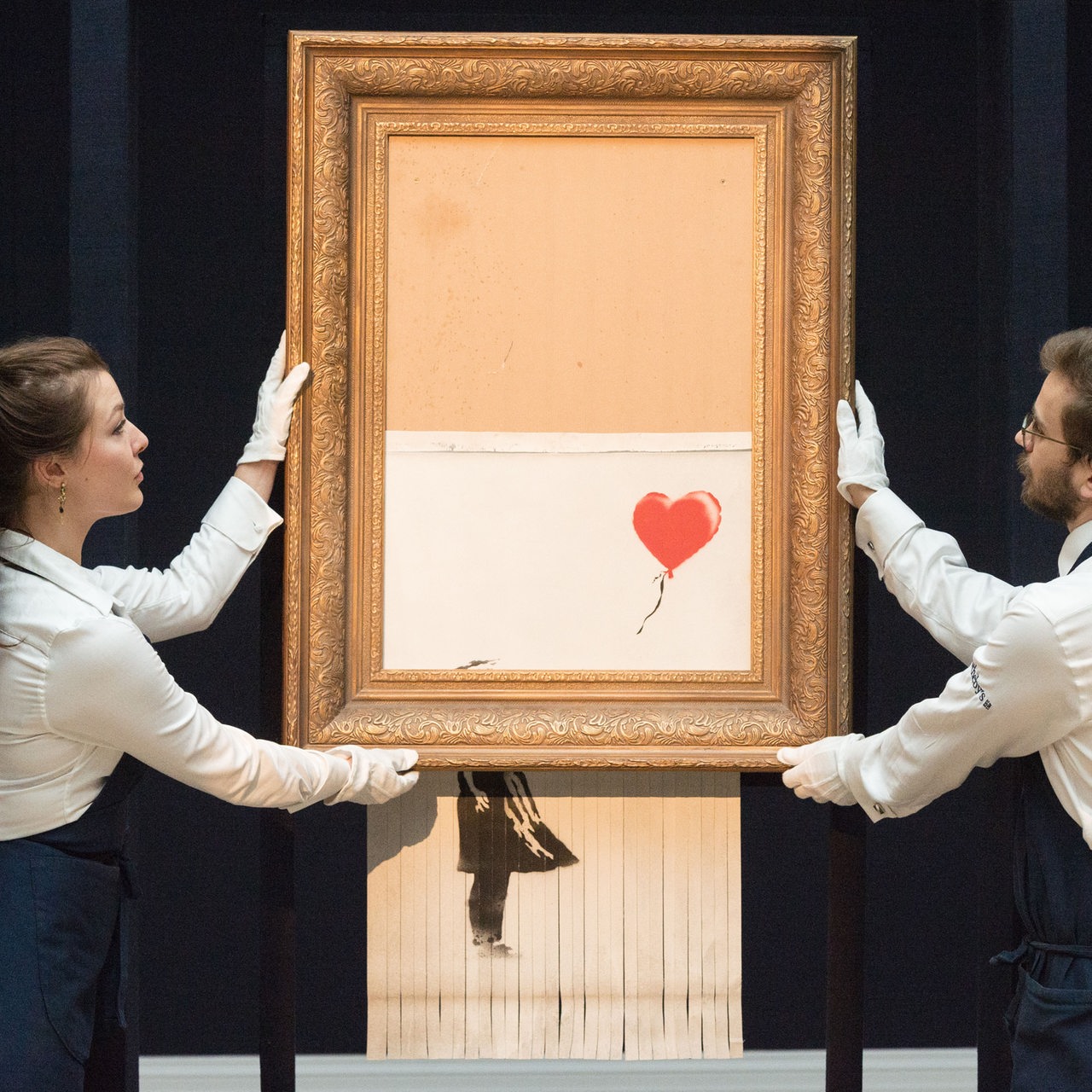 Das Gemälde von Banksy "Love Is In The Bin", wird auf einer Auktion präsentiert und von durch einen Selbstzerstörungsmechanismus geschreddert.