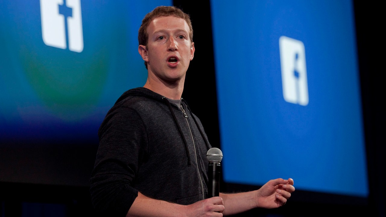 Mark Zuckerberg 2013 vor dem Facebook Logo