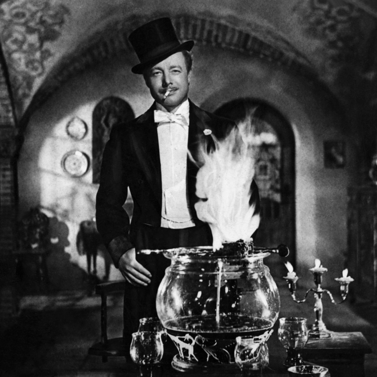 Heinz Rühmann mit Zigarette und Zylinder vor der "Feuerzangenbowle" aus dem gleichnamigen Film.