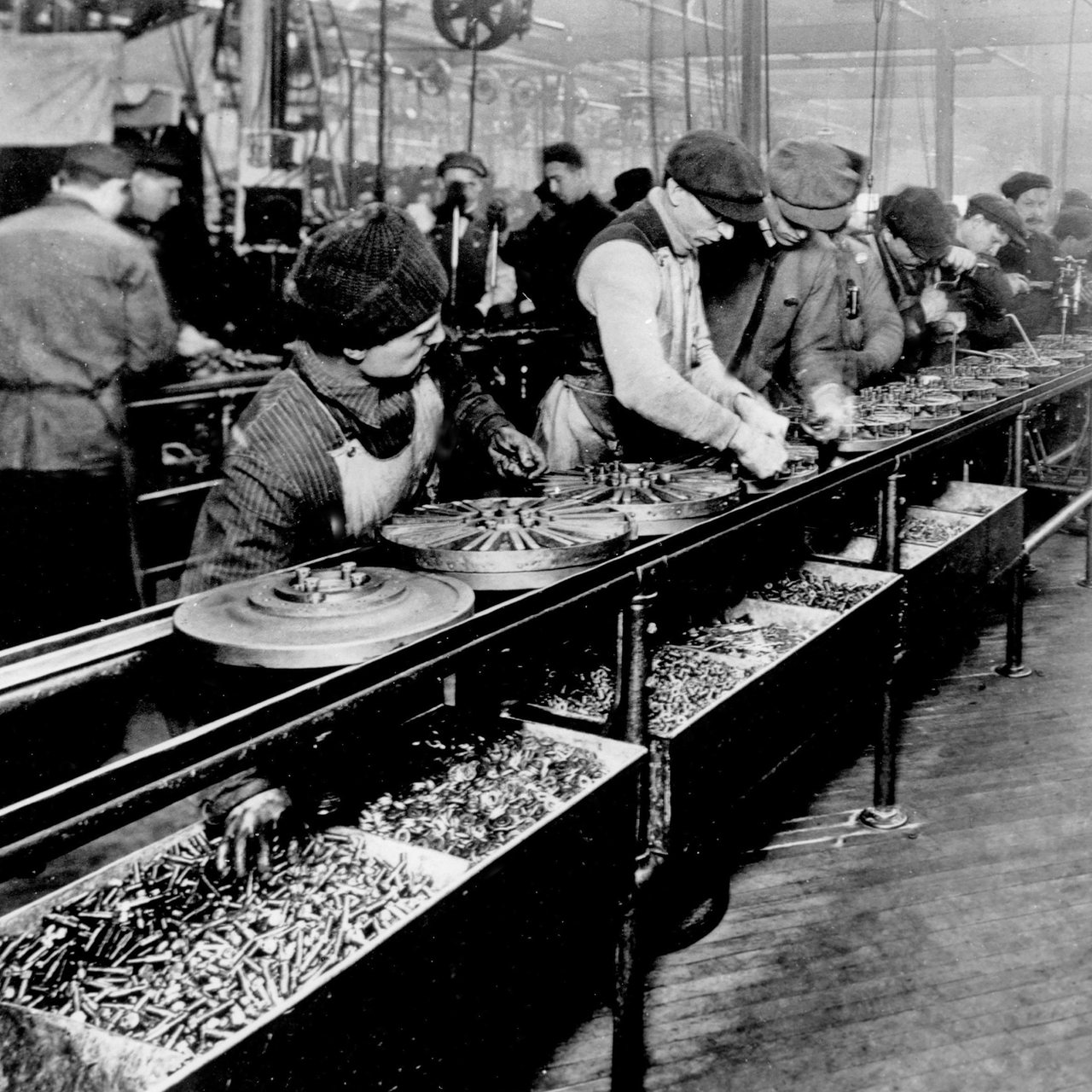 Historische Aufnahme von 1913 zeigt Arbeiter am Fließband in einem Fordwerk in den USA.