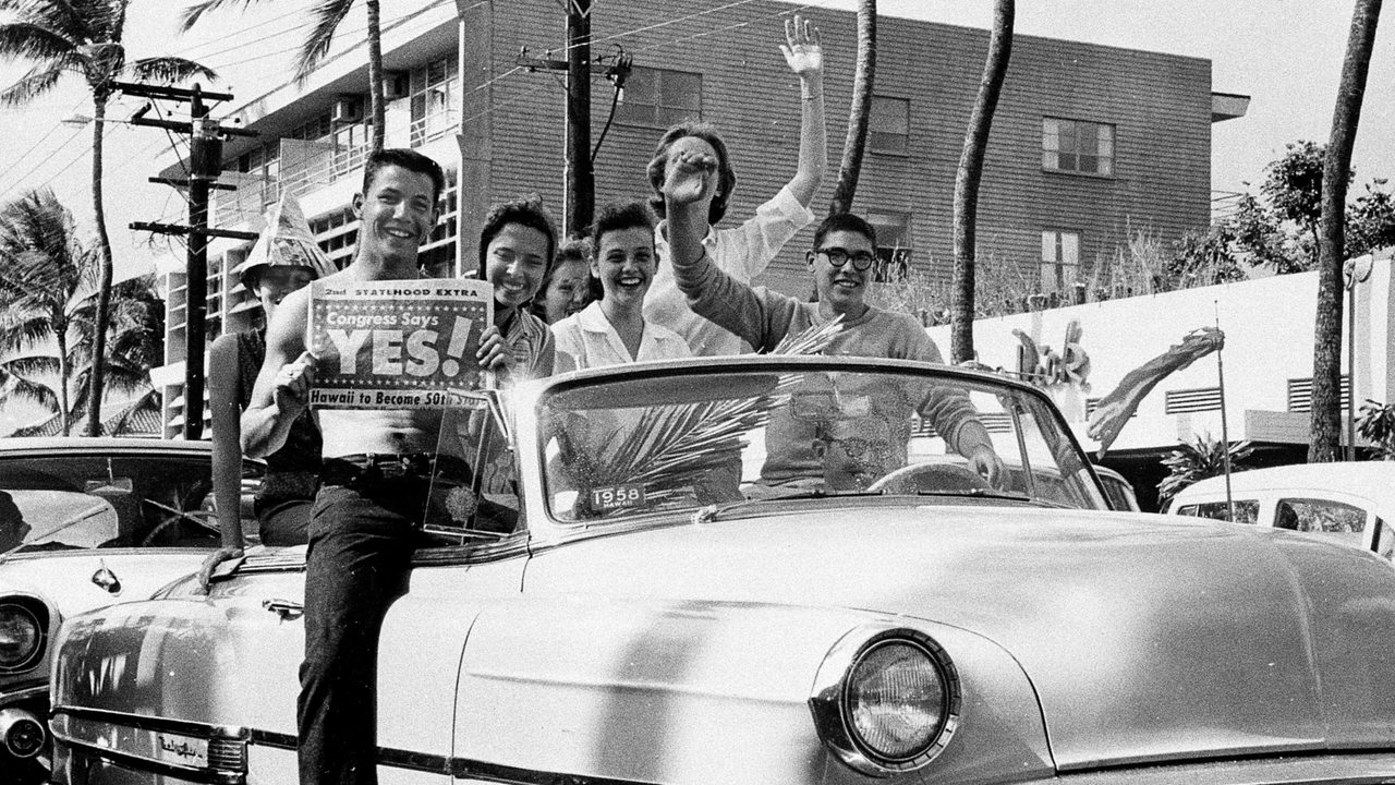 Eine Gruppe junger Unterstützer des Beitritts von Hawaii in die USA fährt in einem Cabrio mit einem Plakat durch Honolulu/Hawaii 1959.