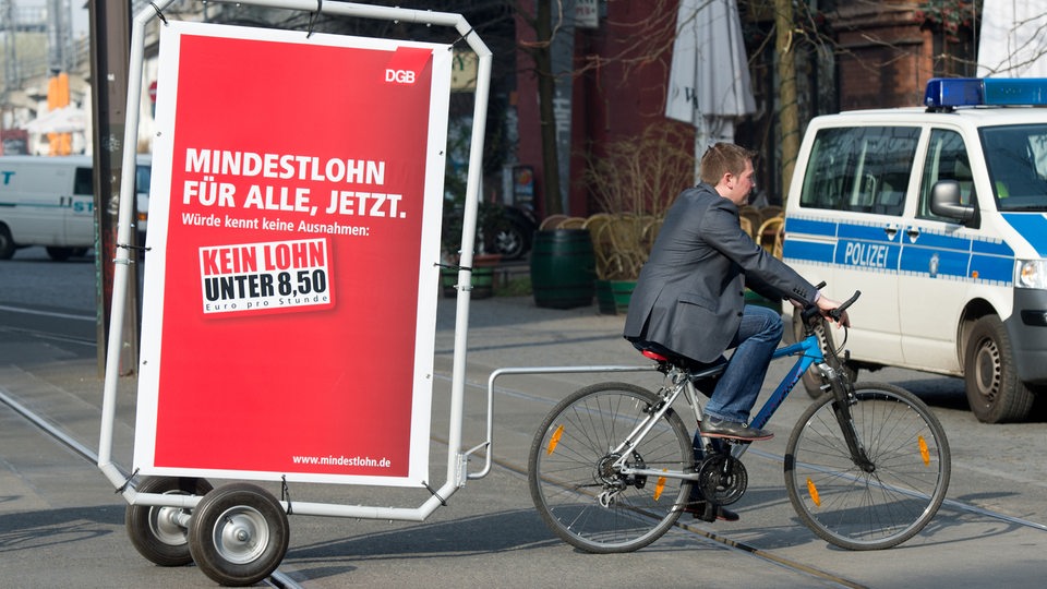 Gewerkschaftsmitarbeiter fahren am 01.04.2014 in Berlin mit mobilen Werbeplakaten der neuen Mindestlohn-Kampagne des DGB mit dem Slogan "Mindestlohn für alle, jetzt. Würde kennt keine Ausnahmen: Kein Lohn unter 8,50 Euro." herum.