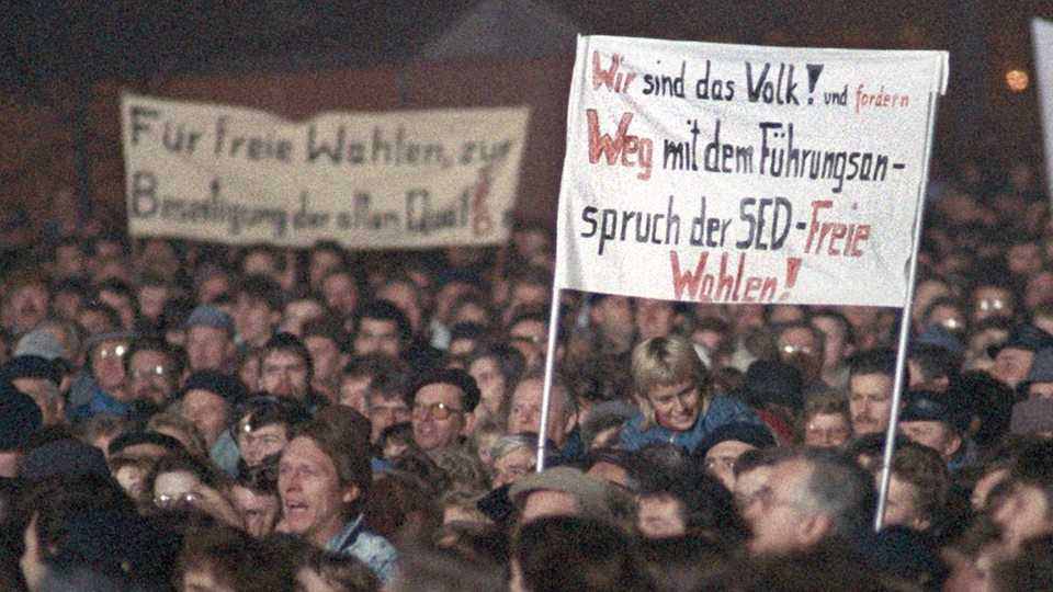 Auf einer Montagsdemonstration 1989 in Leipzig fordern die Bürger u.a. freie Wahlen.