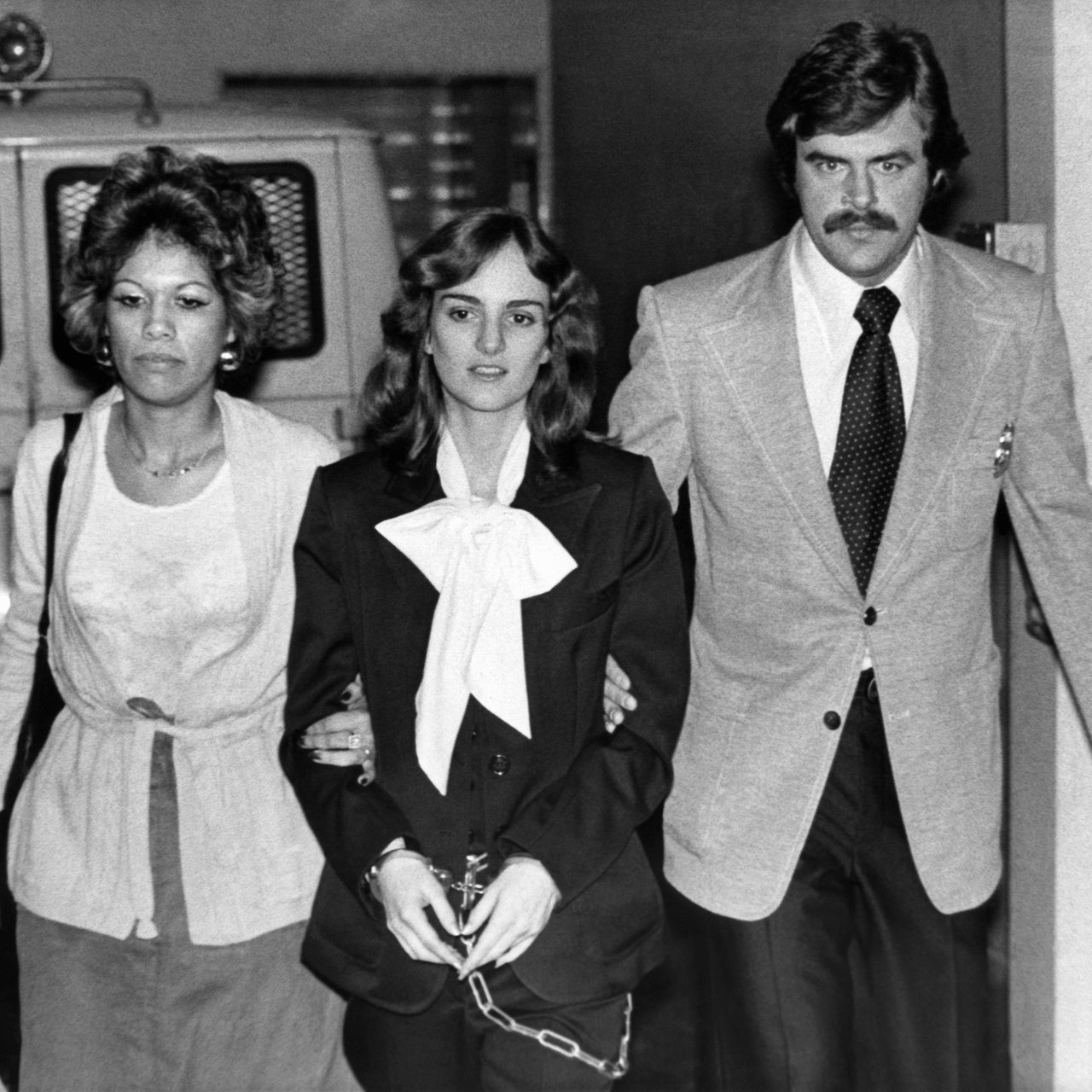 Patricia Hearst wird 1976 von zwei US Marshalls in Handschellen abgeführt.