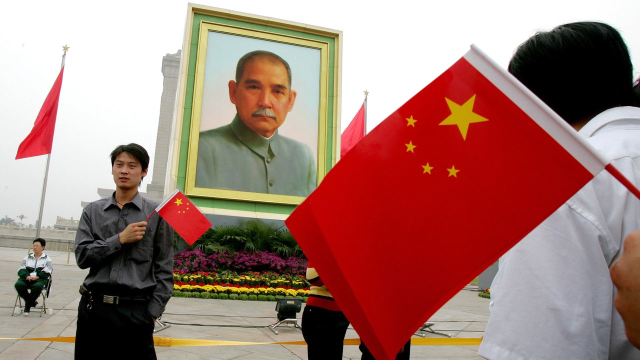 Chinesische Besucher posieren mit Flaggen vor einem Porträt von Sun Yat-sen