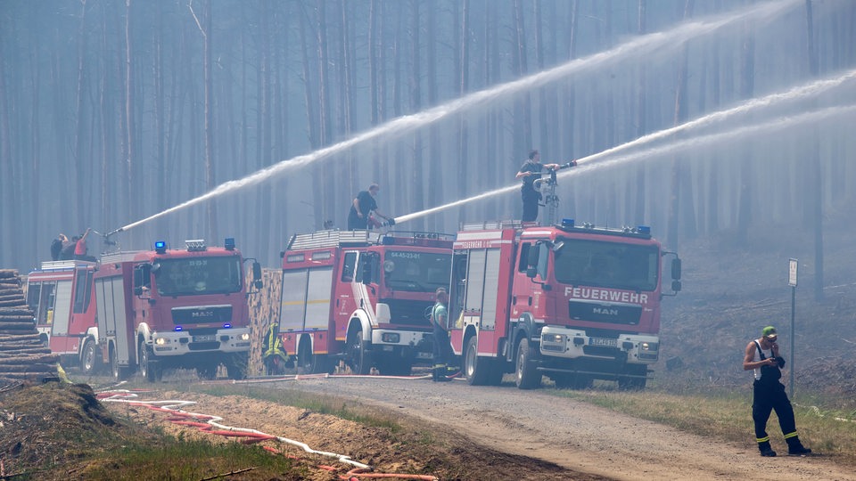 Feuerwehrleute löschen einen großflächigen Waldbrand in der Nähe des ehemaligen Truppenübungsplatz bei Lübtheen 